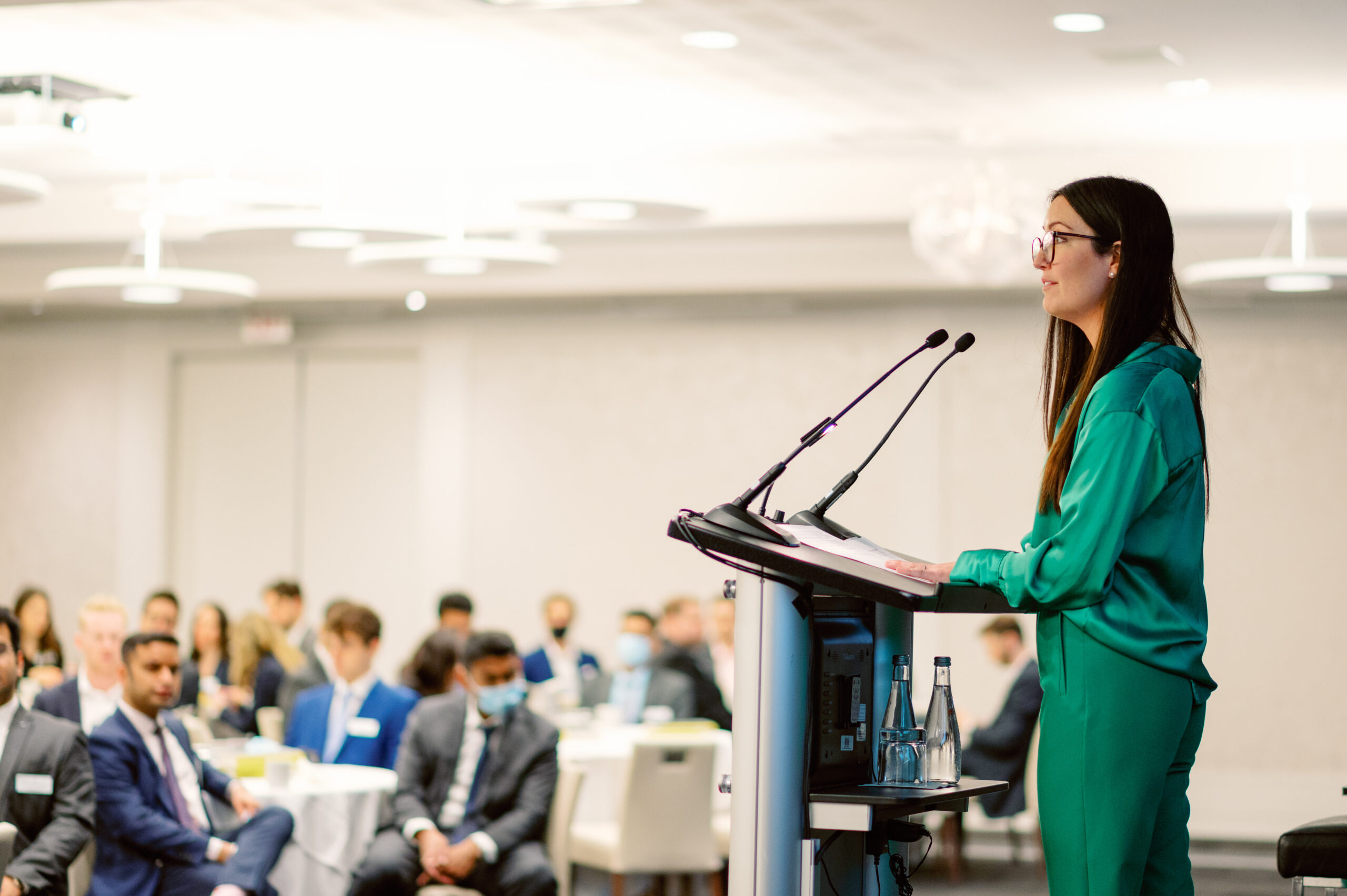 Female speaker at talking at podium to conference audience