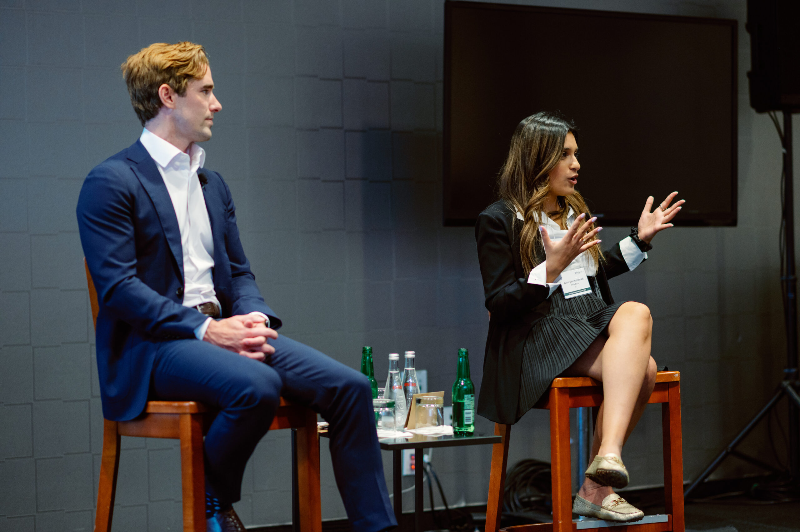 A panel of a male and female speakers on stage at a conference